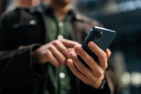 Person håller en smartphone och trycker på skärmen